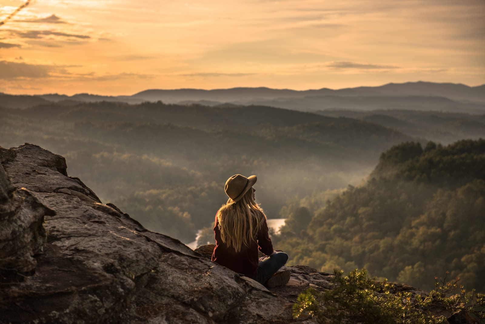 Jeune fille assise qui contemple la montagne.